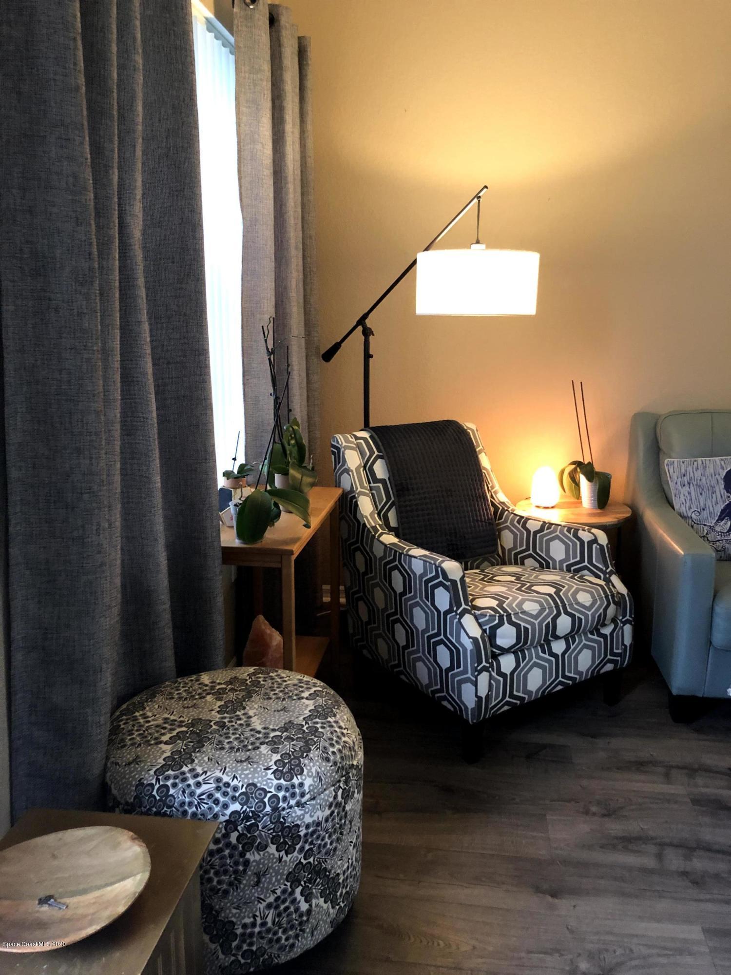 100 Turpial Way, Unit 107 Melbourne, FL 32901 - Photo 5 of 49 a bedroom with a bed and a chandelier