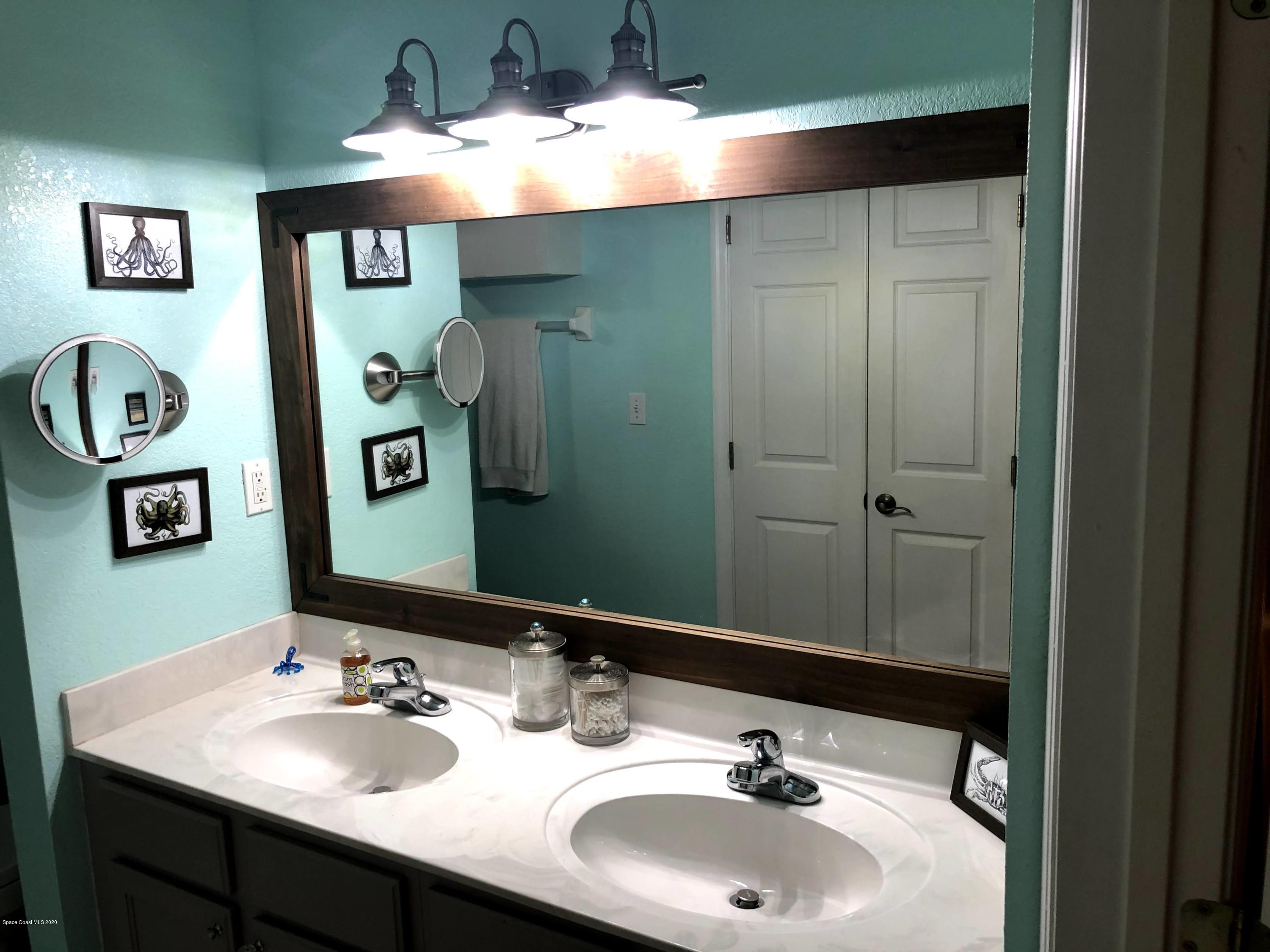 100 Turpial Way, Unit 107 Melbourne, FL 32901 - Photo 41 of 49 a bathroom with a sink and a mirror
