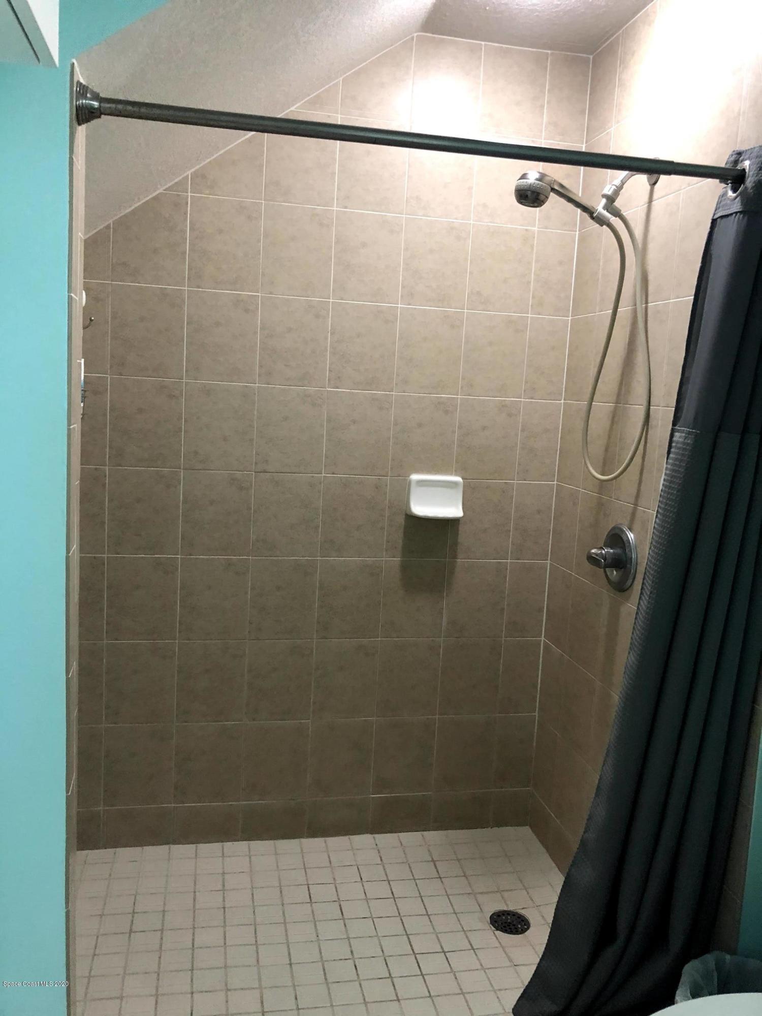 100 Turpial Way, Unit 107 Melbourne, FL 32901 - Photo 44 of 49 a bathroom with a shower