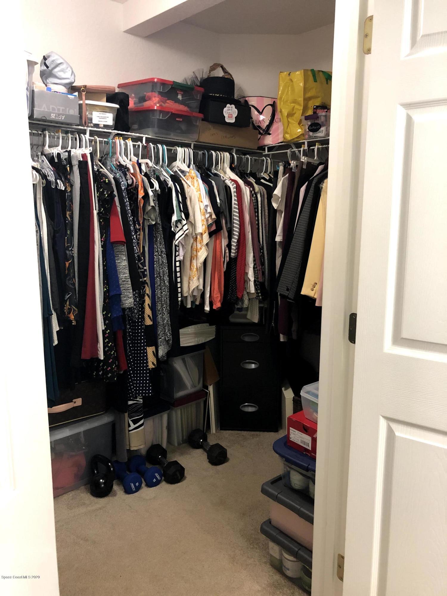 100 Turpial Way, Unit 107 Melbourne, FL 32901 - Photo 47 of 49 a view of walk in closet with clothes and shoes