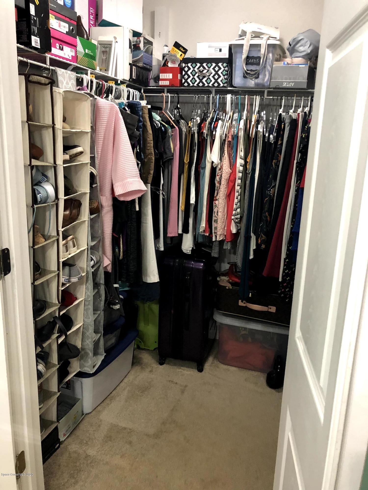 100 Turpial Way, Unit 107 Melbourne, FL 32901 - Photo 48 of 49 a view of walk in closet with clothes and shoes