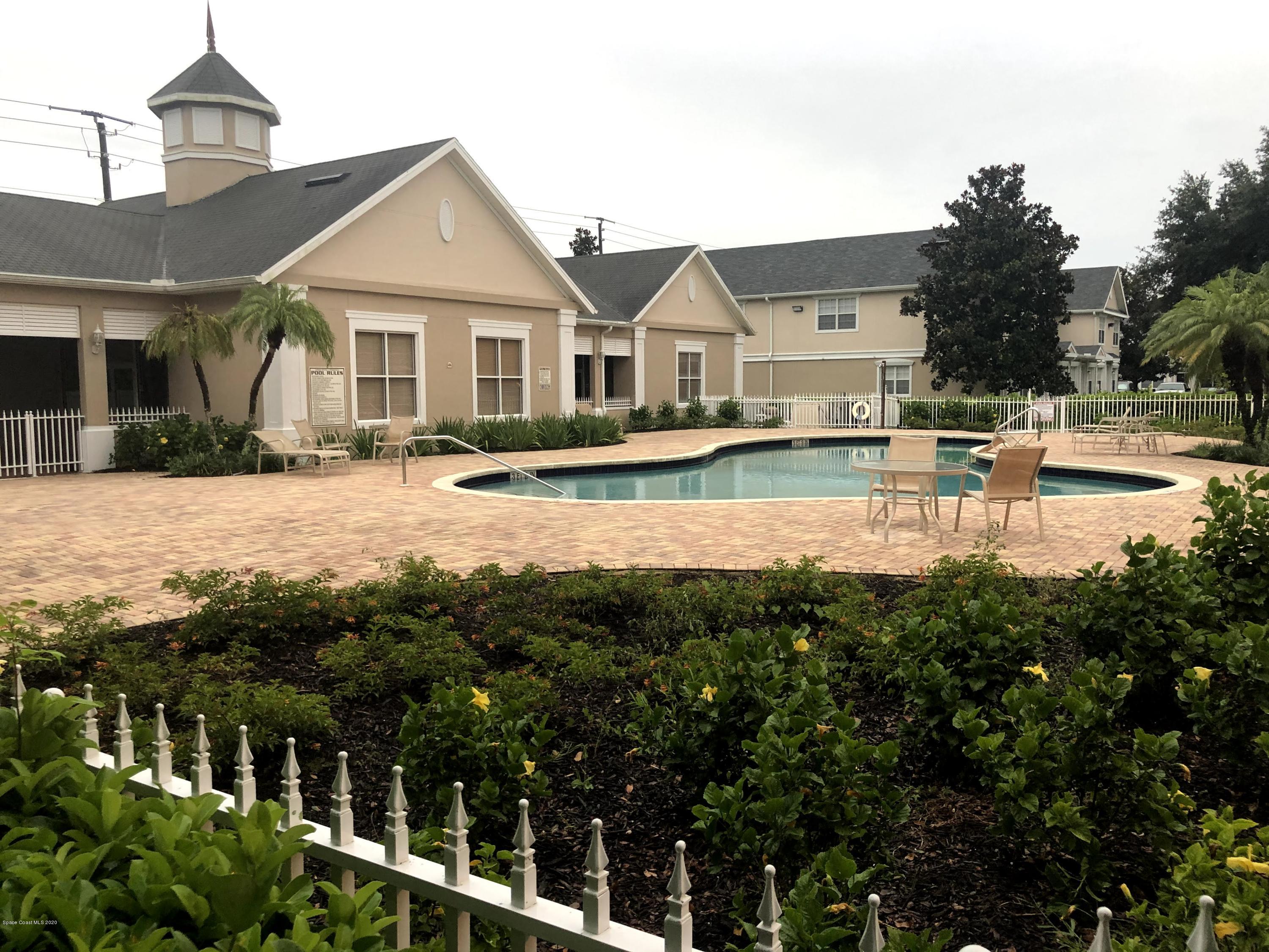 100 Turpial Way, Unit 107 Melbourne, FL 32901 - Photo 49 of 49 a front view of a house with a yard table and chairs