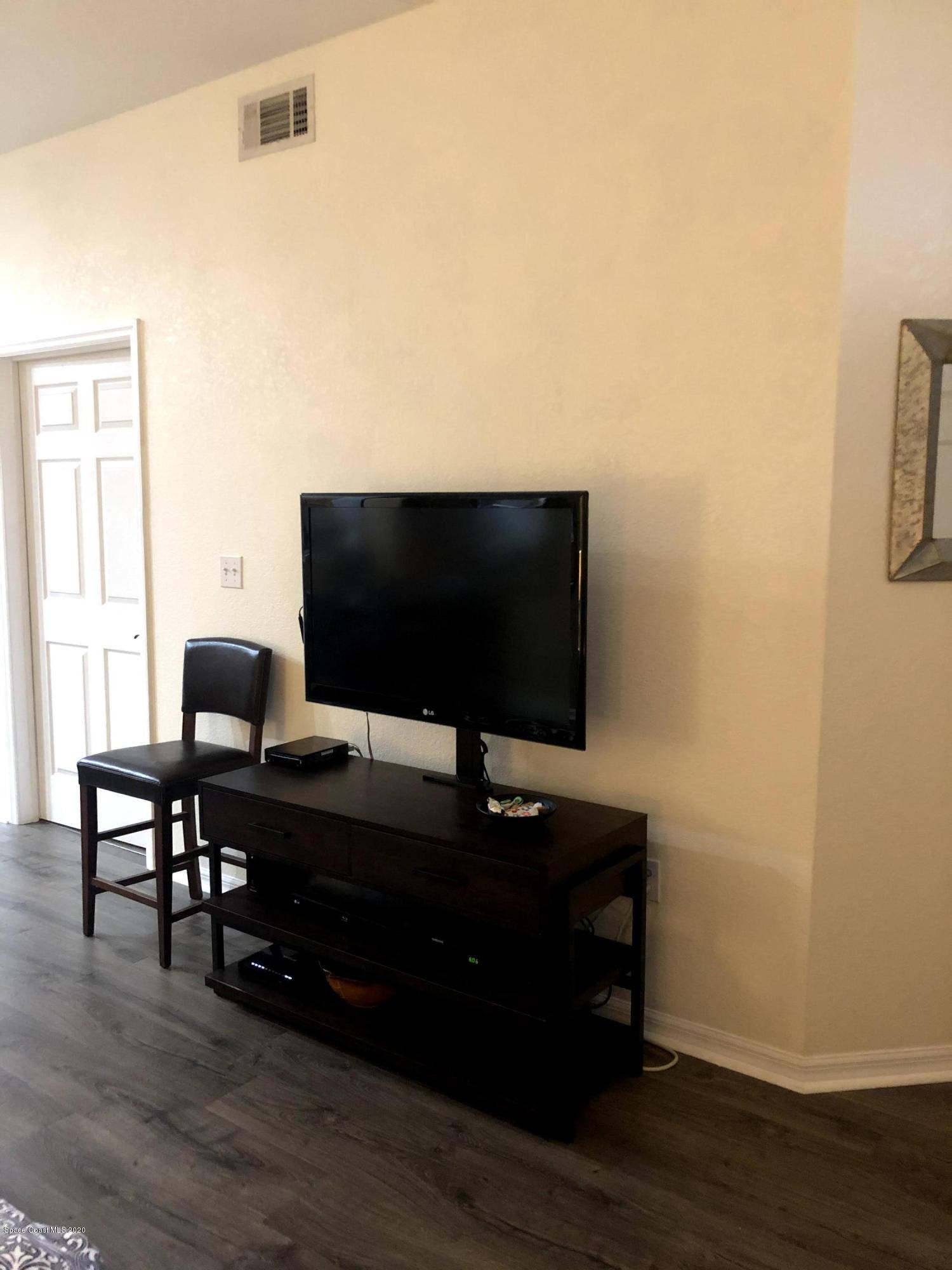 100 Turpial Way, Unit 107 Melbourne, FL 32901 - Photo 7 of 49 a living room with a flat screen tv and furniture