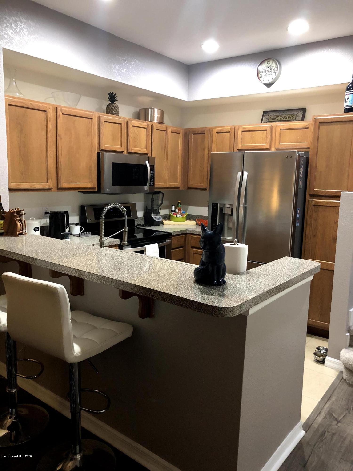 100 Turpial Way, Unit 107 Melbourne, FL 32901 - Photo 8 of 49 a kitchen with a table chairs sink and refrigerator