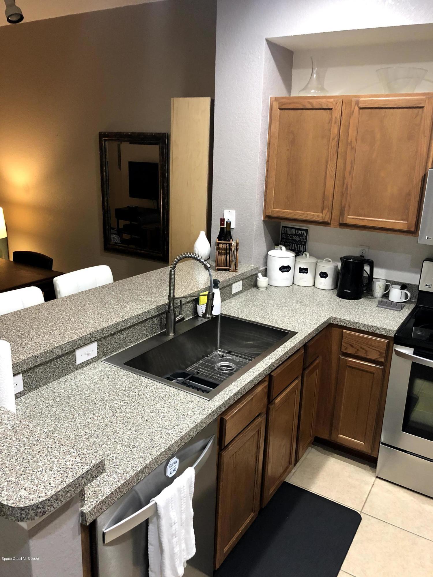100 Turpial Way, Unit 107 Melbourne, FL 32901 - Photo 9 of 49 a kitchen with a sink and a refrigerator