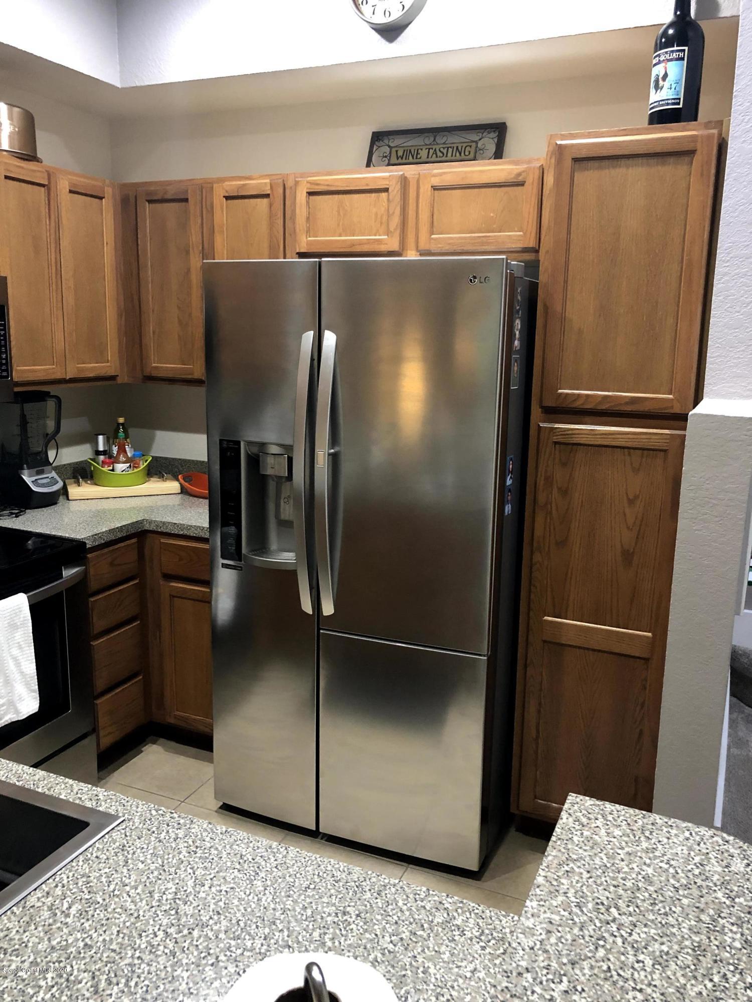 100 Turpial Way, Unit 107 Melbourne, FL 32901 - Photo 10 of 49 a kitchen with stainless steel appliances granite countertop a refrigerator and a stove