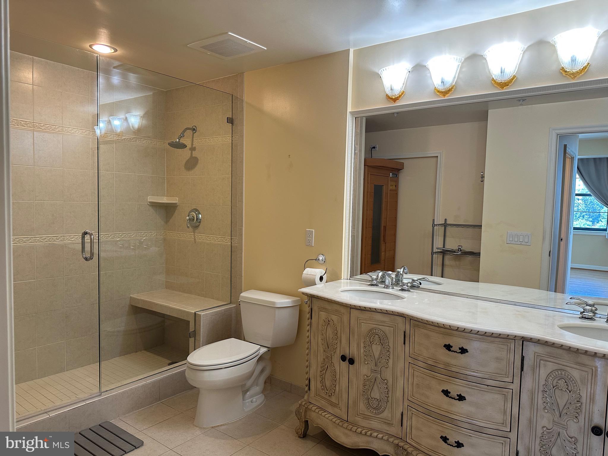 1830 Fountain Drive, Unit 607 Reston, VA 20190 - Photo 15 of 26 a bathroom with a toilet a sink a mirror and a shower