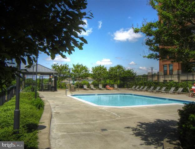 1830 Fountain Drive, Unit 607 Reston, VA 20190 - Photo 25 of 26 a view of swimming pool with outdoor seating and trees in the background
