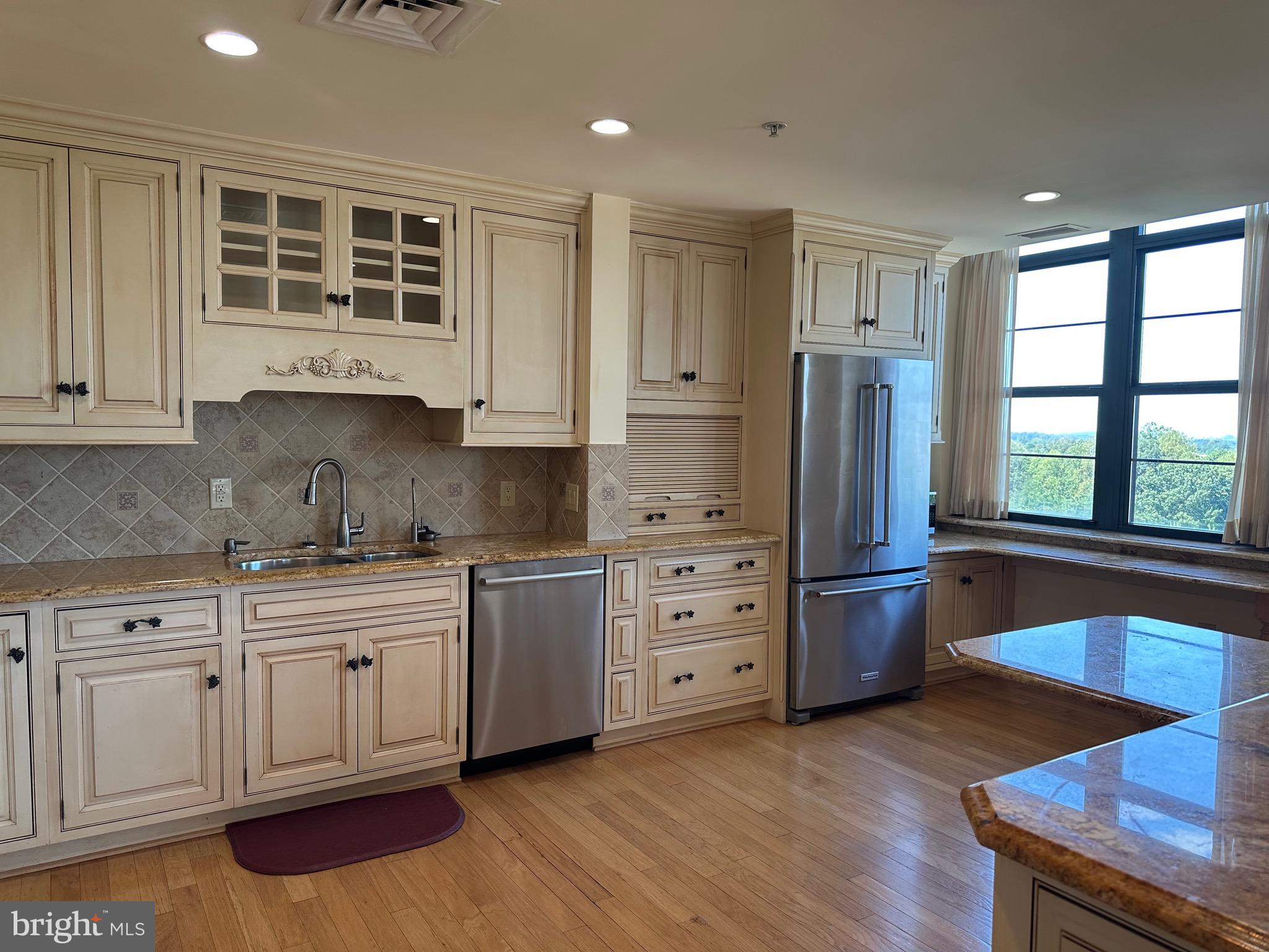 1830 Fountain Drive, Unit 607 Reston, VA 20190 - Photo 9 of 26 a kitchen with stainless steel appliances granite countertop a stove a sink dishwasher and a refrigerator with wooden floor