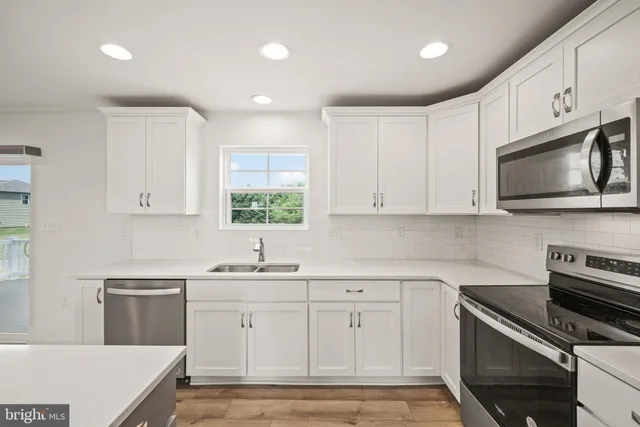 a kitchen with white cabinets stainless steel appliances and sink