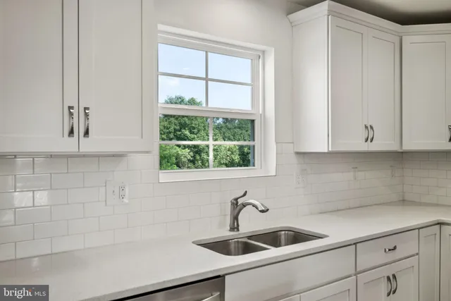 a kitchen with white cabinets and a sink
