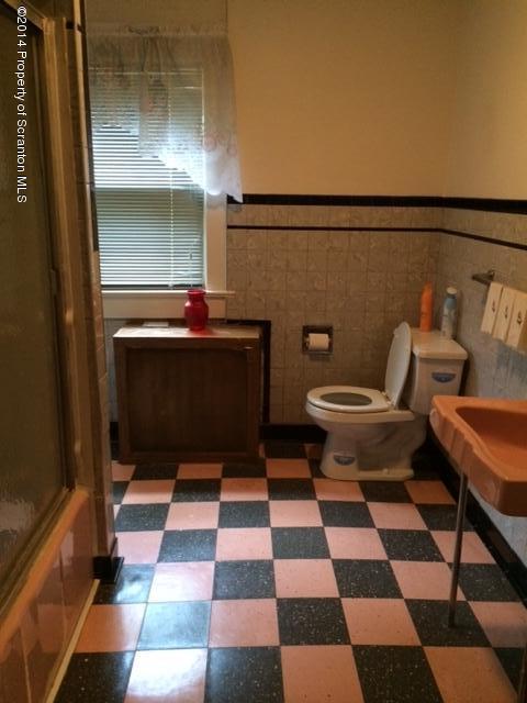 406 North State Street Clarks Summit, PA 18411 - Photo 6 of 6 a living room with a black white checkered floor with a gaming machine and dining table