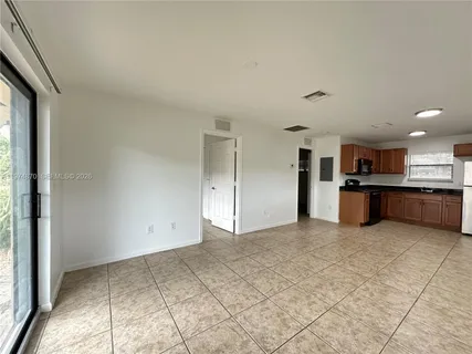 a view of kitchen with kitchen island sink and refrigerator