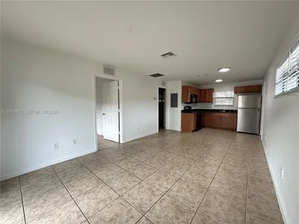 a view of a kitchen with a sink and a refrigerator