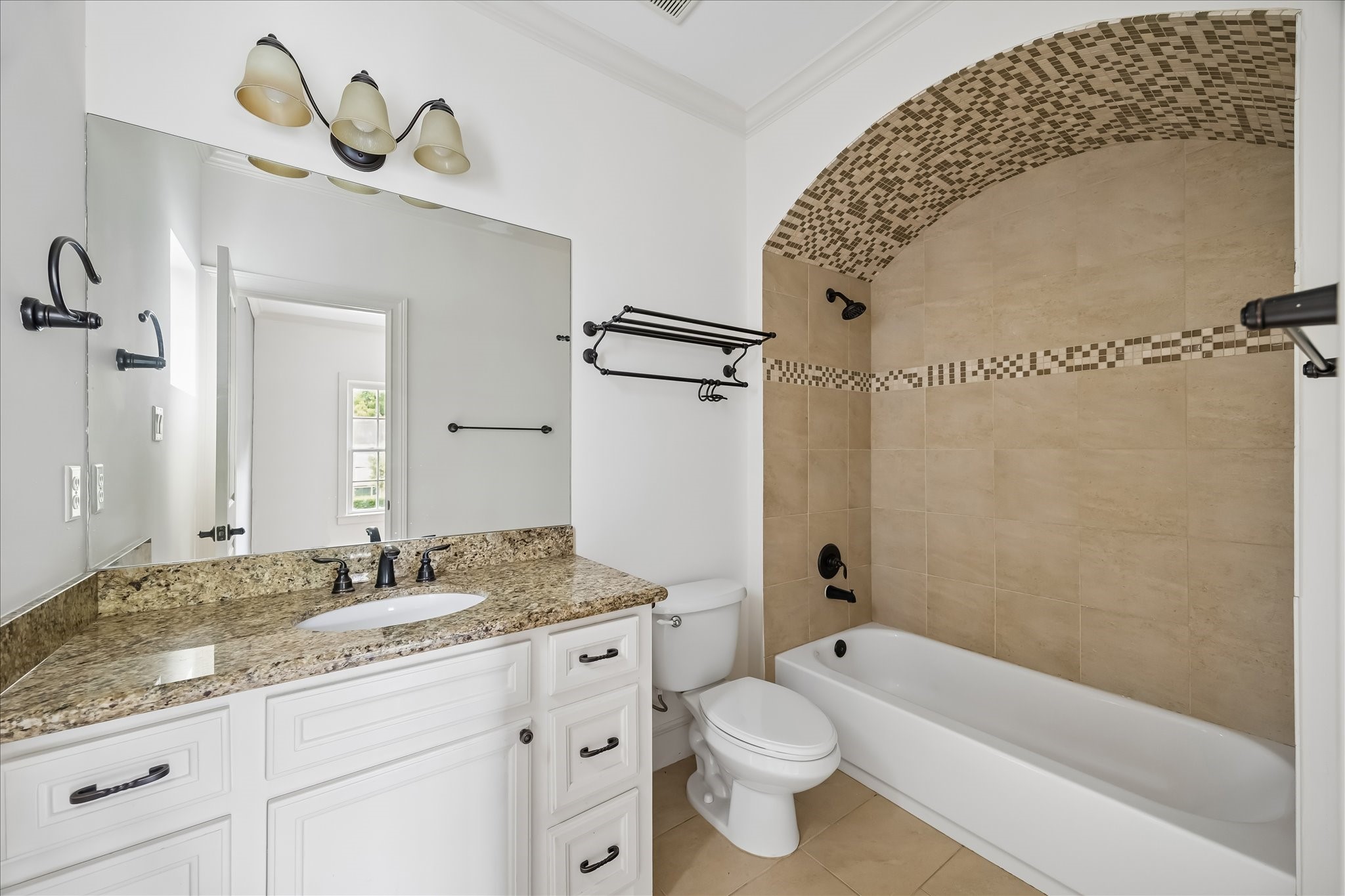 2246 Branard Street Houston, TX 77098 - Photo 35 of 40 Secondary bath with granite vanity, neutral stone finishes, and an elegant arched shower detail.