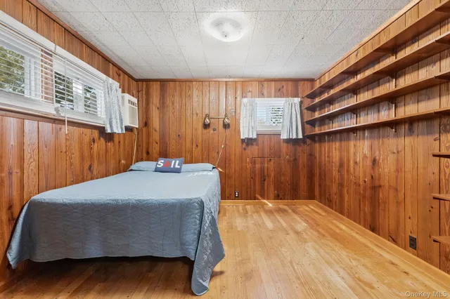 a bedroom with a bed and a flat tv screen on dresser