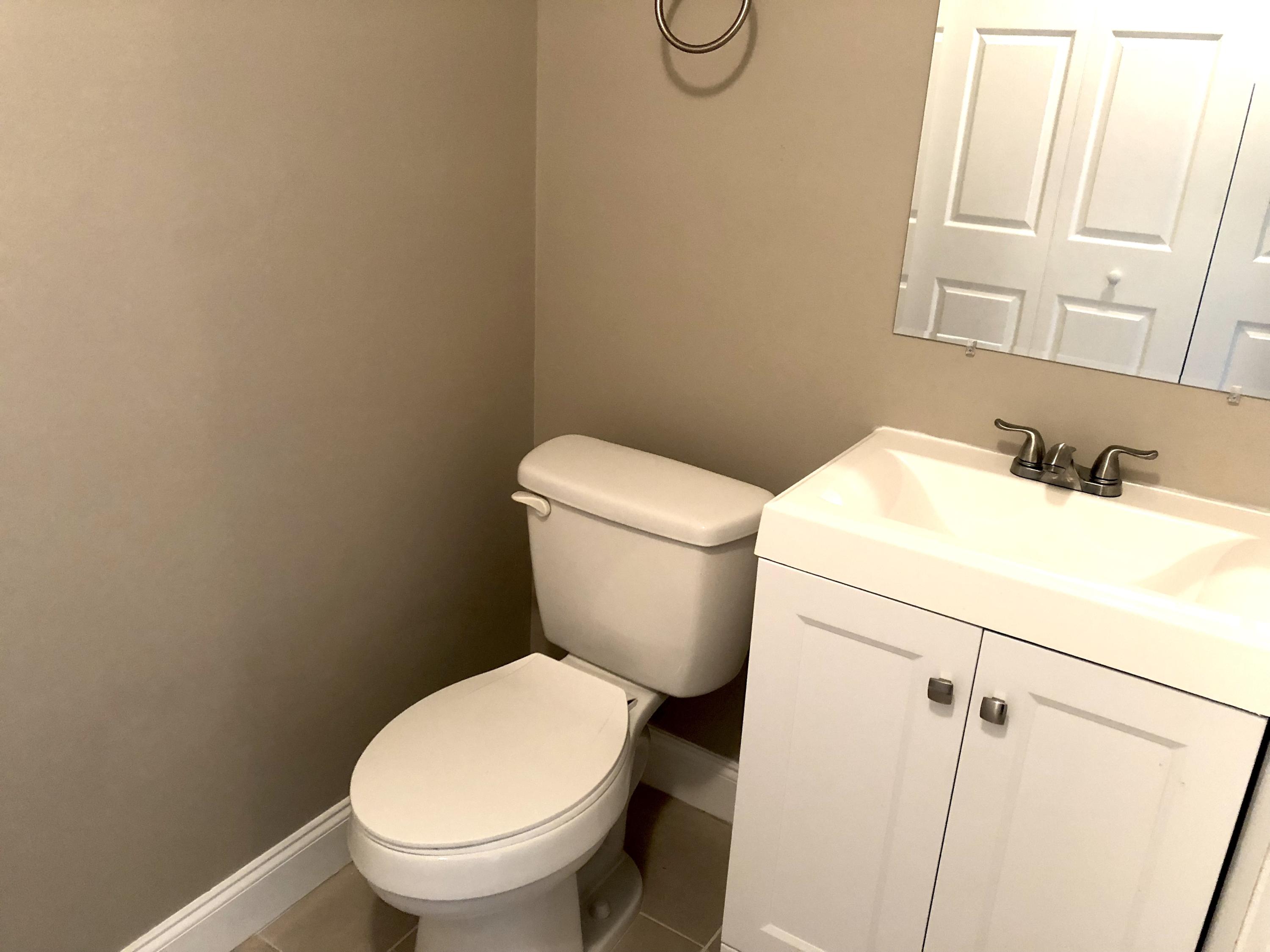 253 Southeast Norfolk Boulevard Stuart, FL 34997 - Photo 11 of 16 a white toilet sitting next to a bathroom sink