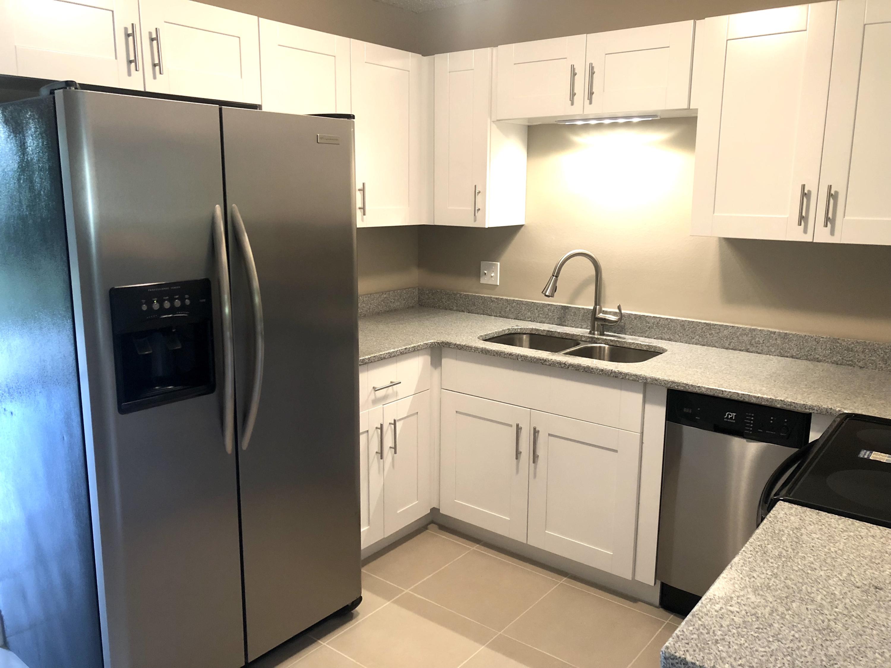 253 Southeast Norfolk Boulevard Stuart, FL 34997 - Photo 2 of 16 a kitchen with stainless steel appliances granite countertop a refrigerator sink and cabinets