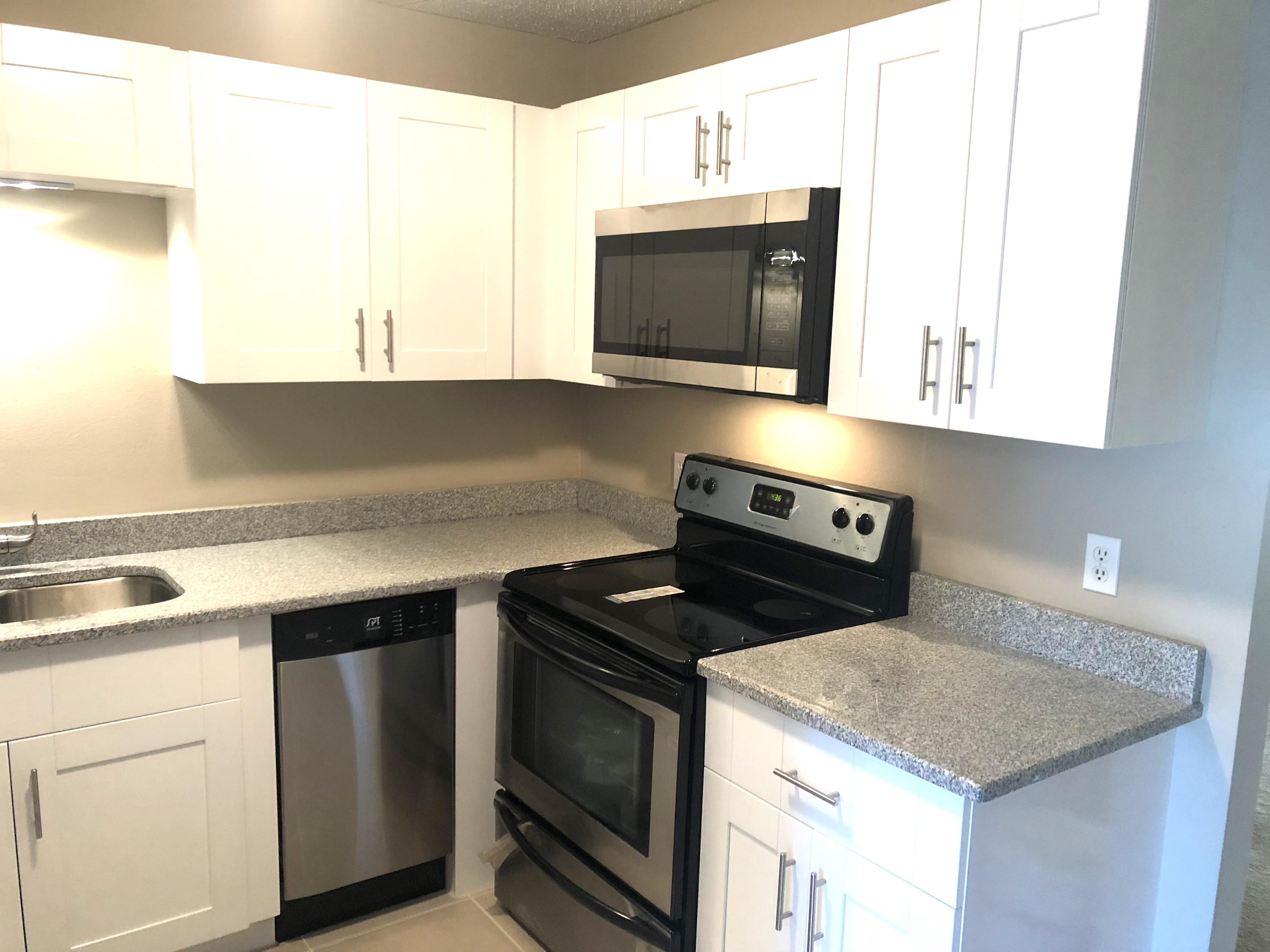 253 Southeast Norfolk Boulevard Stuart, FL 34997 - Photo 3 of 16 a kitchen with a stove and a microwave