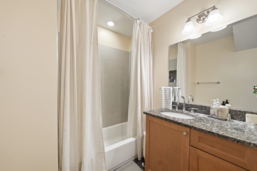 48-50 Carleton Street Newton, MA 02458 - Photo 11 of 19 a bathroom with a granite countertop sink and a mirror