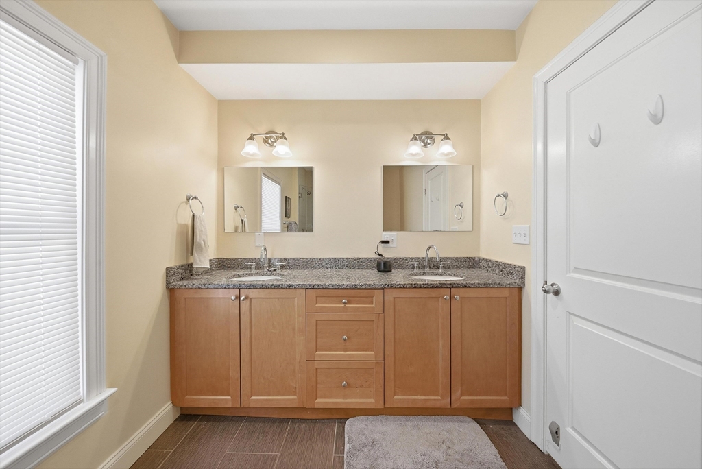 48-50 Carleton Street Newton, MA 02458 - Photo 10 of 19 a bathroom with a granite countertop sink and a mirror
