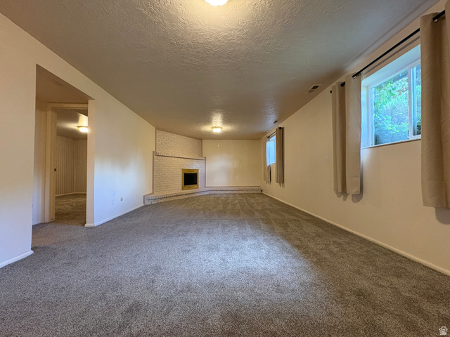 595 Meadowlark Road Orem, UT 84097 - Photo 50 of 87 Spacious carpeted room featuring a white brick fireplace with a dark insert, multiple windows, and recessed lighting