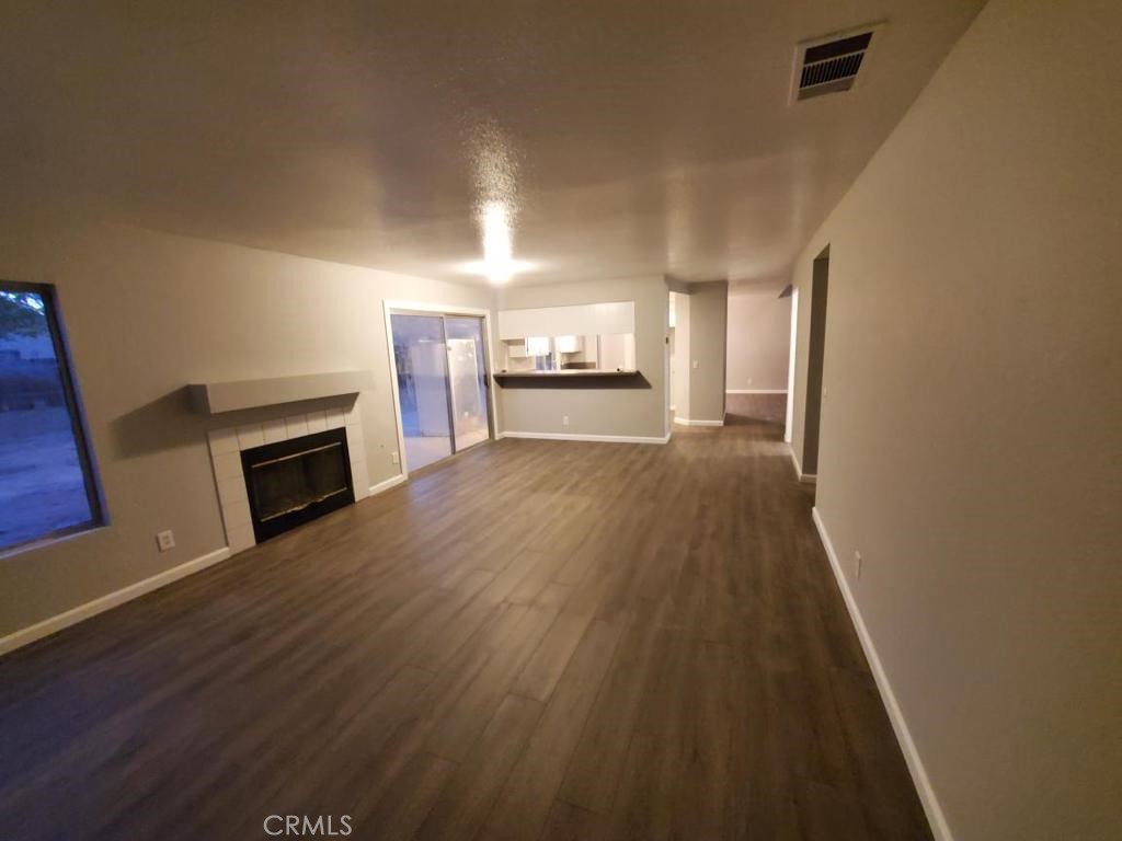 10461 Vintage Road Adelanto, CA 92301 - Photo 1 of 1 a view of a hallway with wooden floor and a fireplace