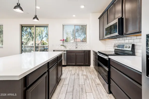 a kitchen with stainless steel appliances granite countertop a refrigerator and a stove top oven