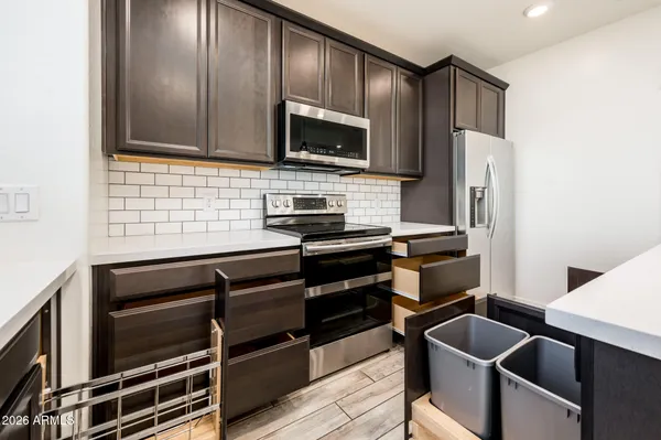 a kitchen with stainless steel appliances kitchen island granite countertop a sink and wooden cabinets