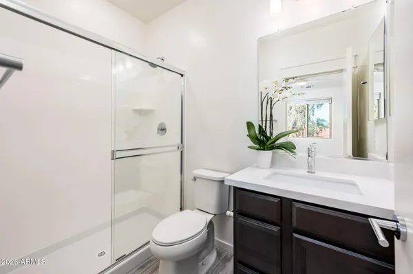 a bathroom with a sink a toilet and shower