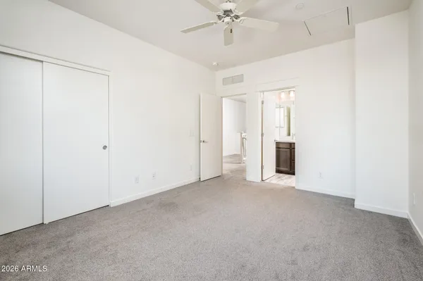 an empty room with closet and chandelier fan