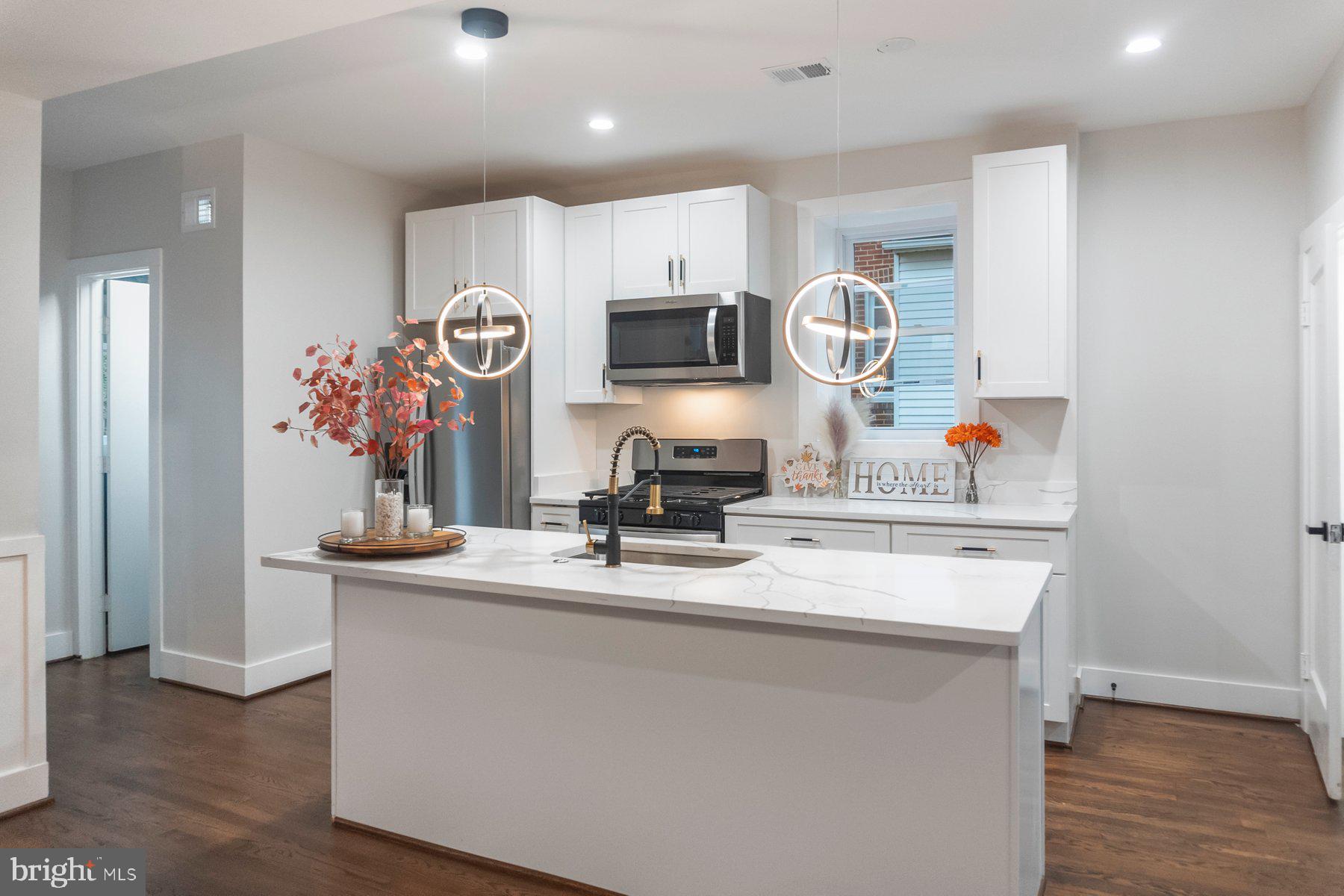 5216 Biddison Lane Baltimore, MD 21206 - Photo 7 of 32 a kitchen with a sink a microwave and cabinets