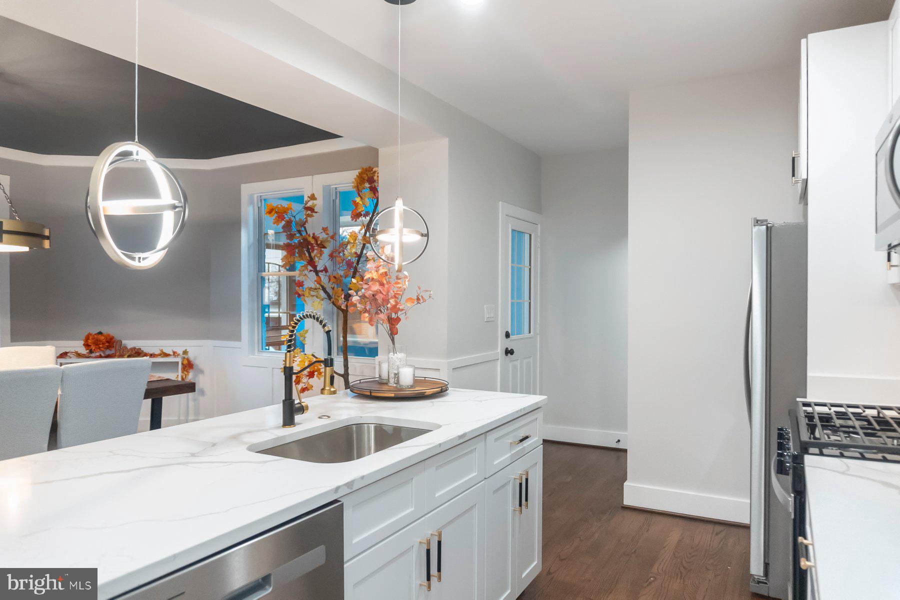 5216 Biddison Lane Baltimore, MD 21206 - Photo 10 of 32 a kitchen with a sink a refrigerator and a table