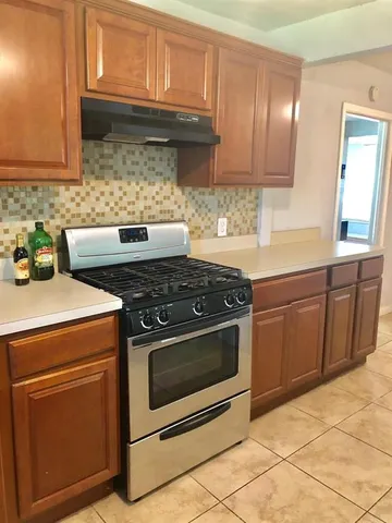 a kitchen with granite countertop a stove top oven microwave and cabinets