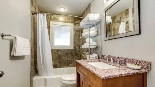 a bathroom with a granite countertop sink toilet and shower