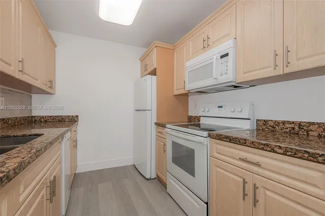 a kitchen with white cabinets and appliances