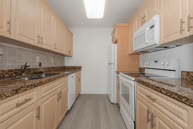 a kitchen with stainless steel appliances granite countertop a stove and a white cabinets
