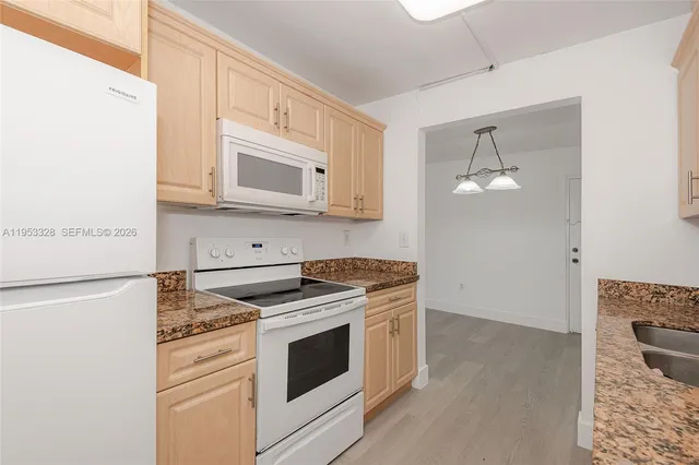 a kitchen with stainless steel appliances granite countertop cabinets and a stove top oven