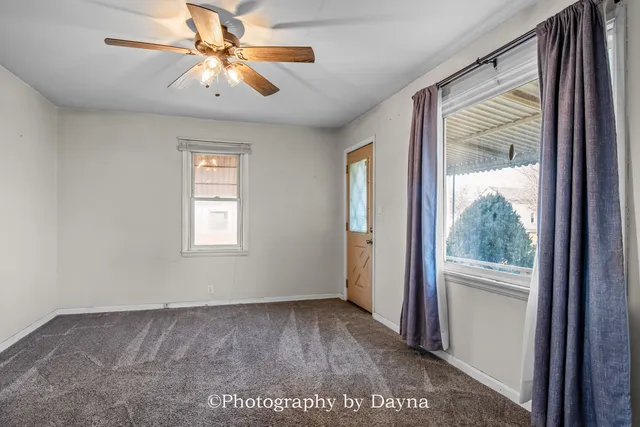 a view of a big room with wooden floor and a chandelier fan