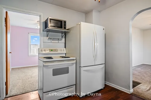 a white refrigerator freezer and a stove sitting inside of a kitchen