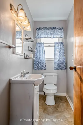 a bathroom with a sink toilet and a mirror