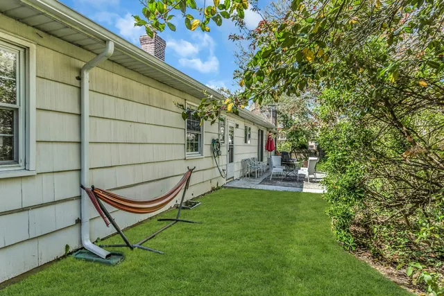 a view of a backyard with table and chairs and potted plants