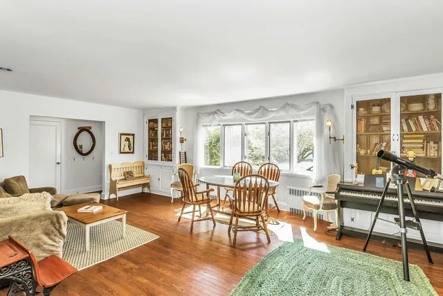 a living room with fireplace furniture and a large window