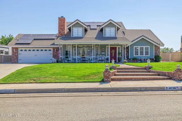 a front view of a house with sitting area and garden
