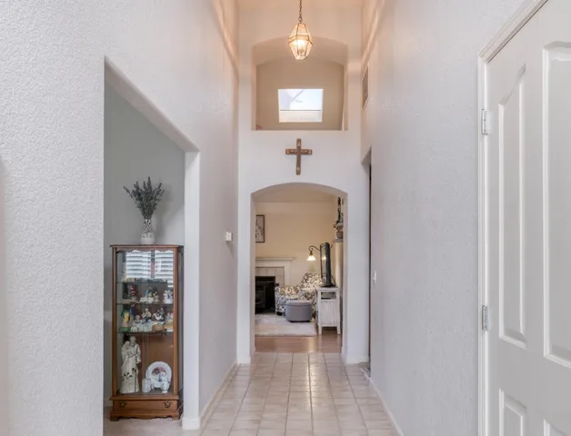a view of a hallway with a livingroom and a bathroom with mirror