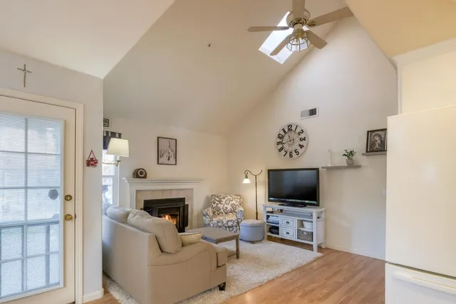 a living room with furniture a flat screen tv and a fireplace