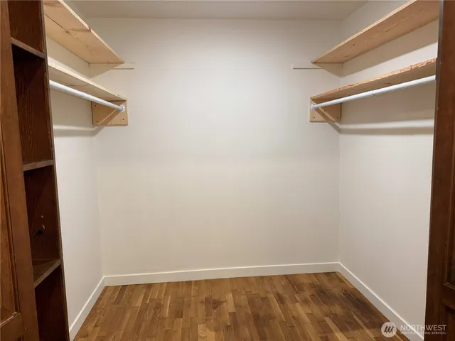 an empty room with wooden floor and fireplace