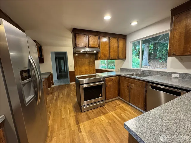 a kitchen with granite countertop a refrigerator and stove