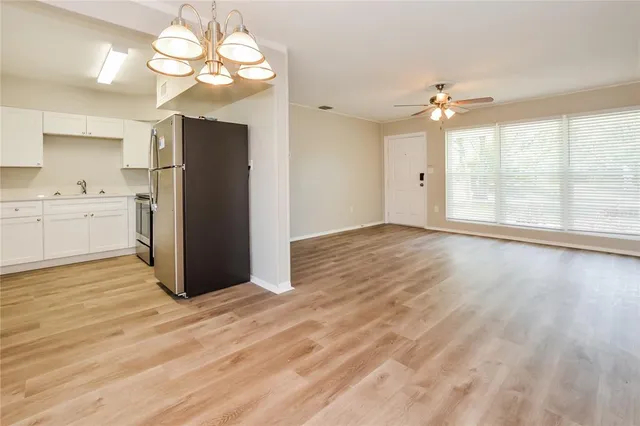a view of a livingroom with a chandelier fan and windows