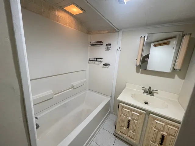 a bathroom with a bathtub sink and mirror